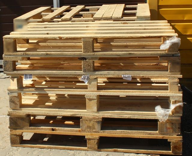Een stapel houten pallets in de zon